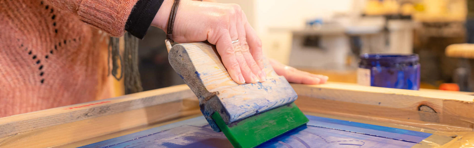 A close up of someone screen printing