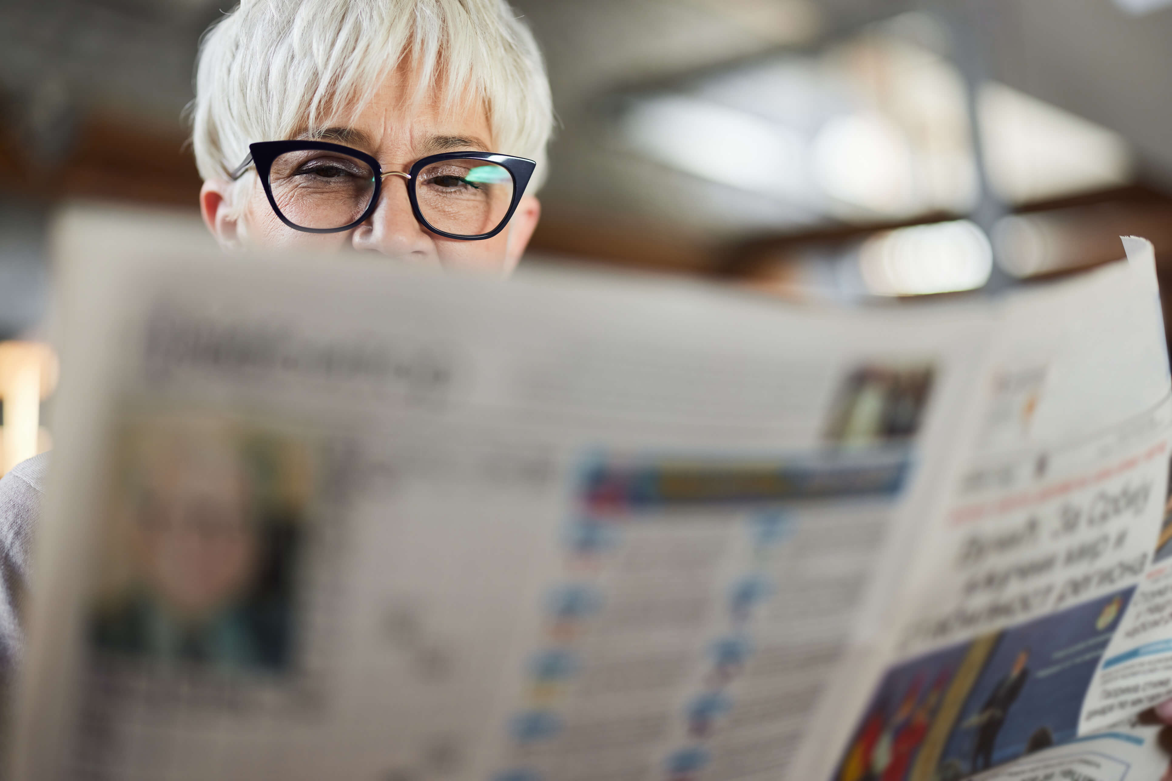 A womam looking at featured items in a newspaper 