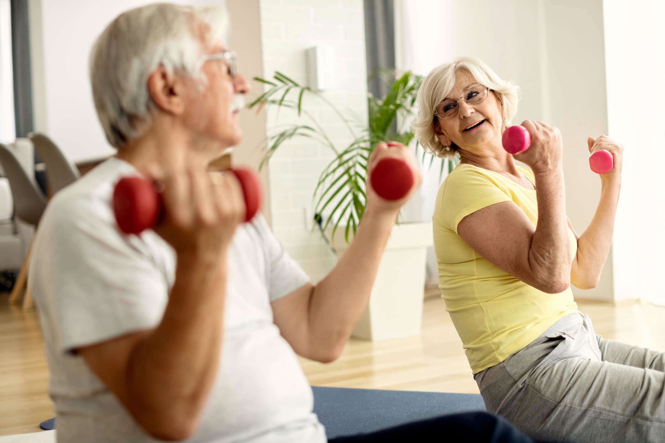 A couple exercising with weights at home 