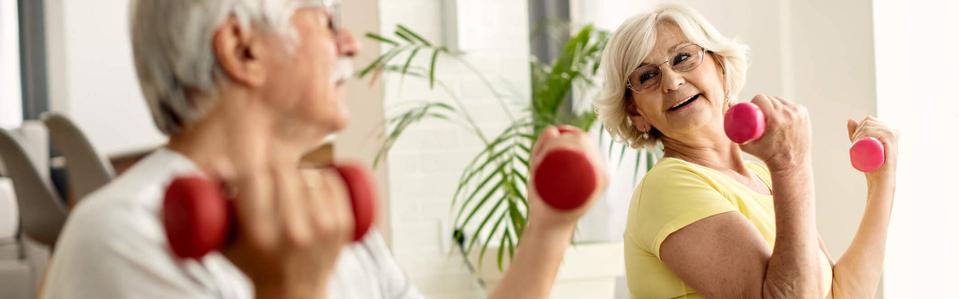 A couple exercising with weights at home