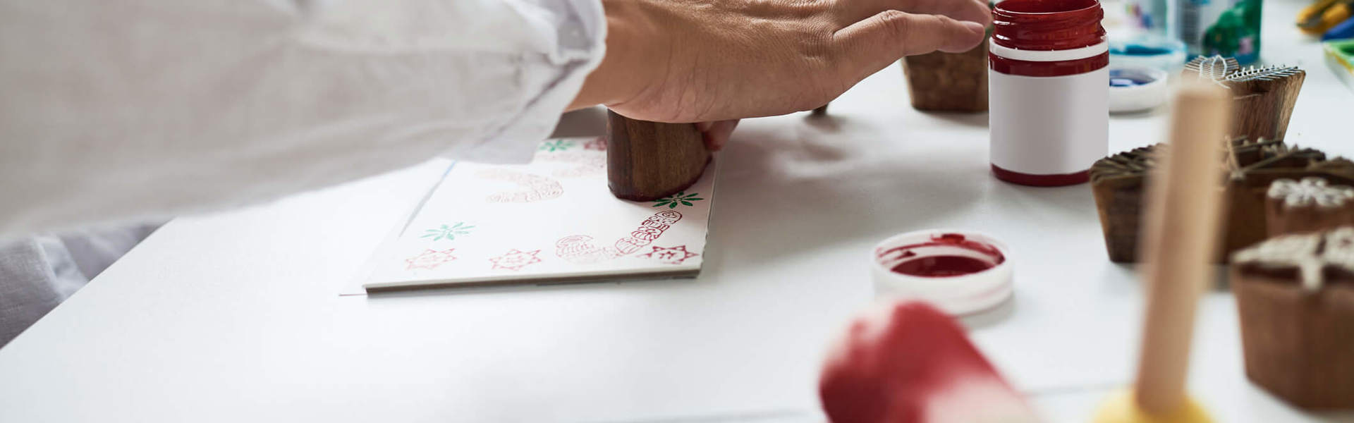 A close up of someone making stamped Christmas cards