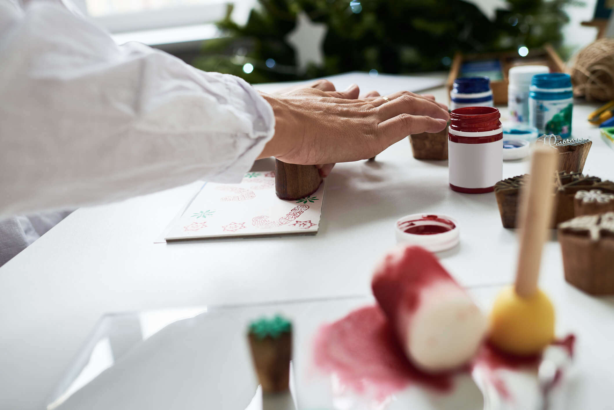 A close up of someone making stamped Christmas cards