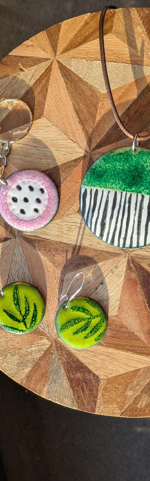 Main image: handmade enamel jewellery pendants, greens and pinks, with various patterns. 