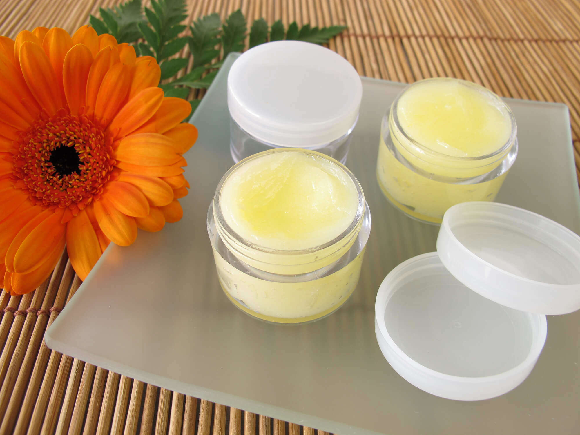 two containers of homemade yellow lip balm 