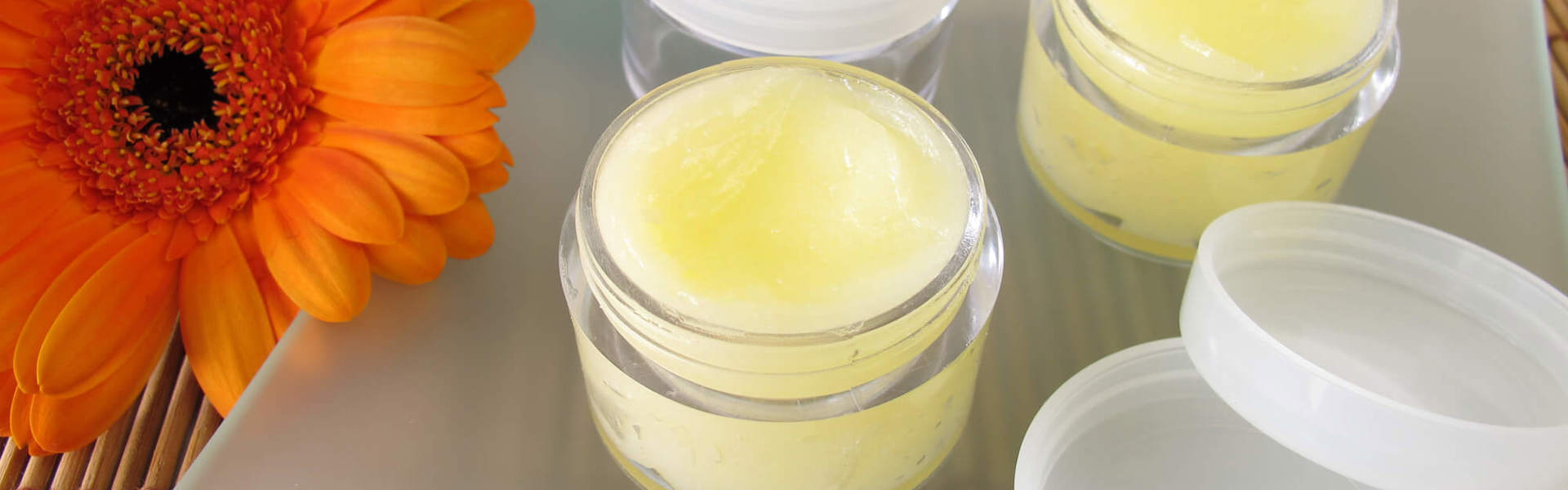 two containers of homemade yellow lip balm