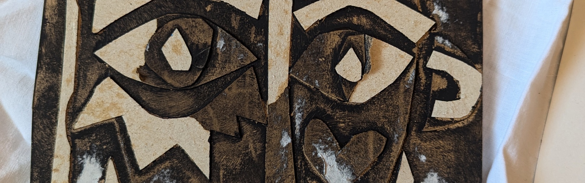 Main image: An Abstract Collage Face made from a Cereal Box - brown cardboard with details painted in black.