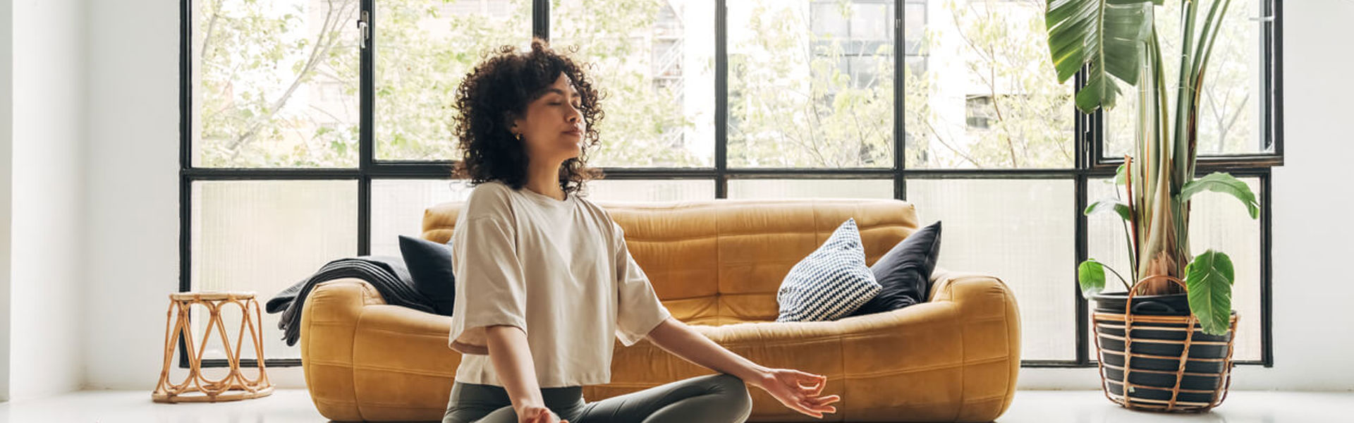 Young multiracial latina woman meditating at home with online video meditation lesson using laptop. Meditation and spirituality concept.