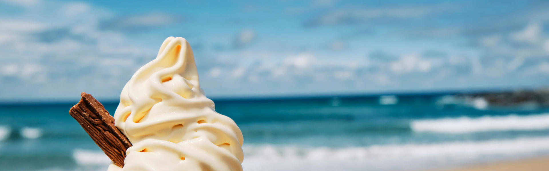 a 99 cone ice cream with a flake against the backdrop of a seaside view