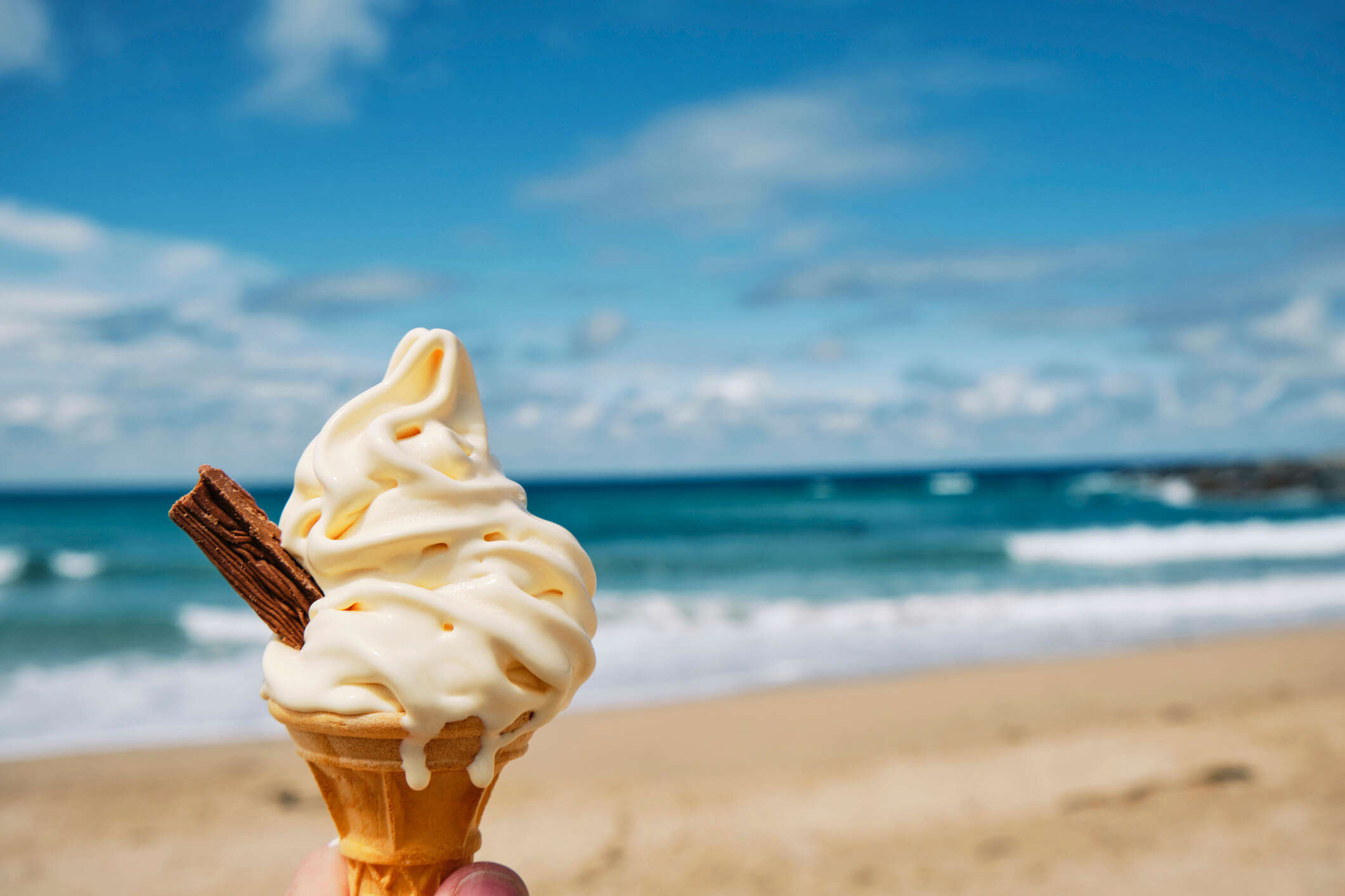 a 99 cone ice cream with a flake against the backdrop of a seaside view