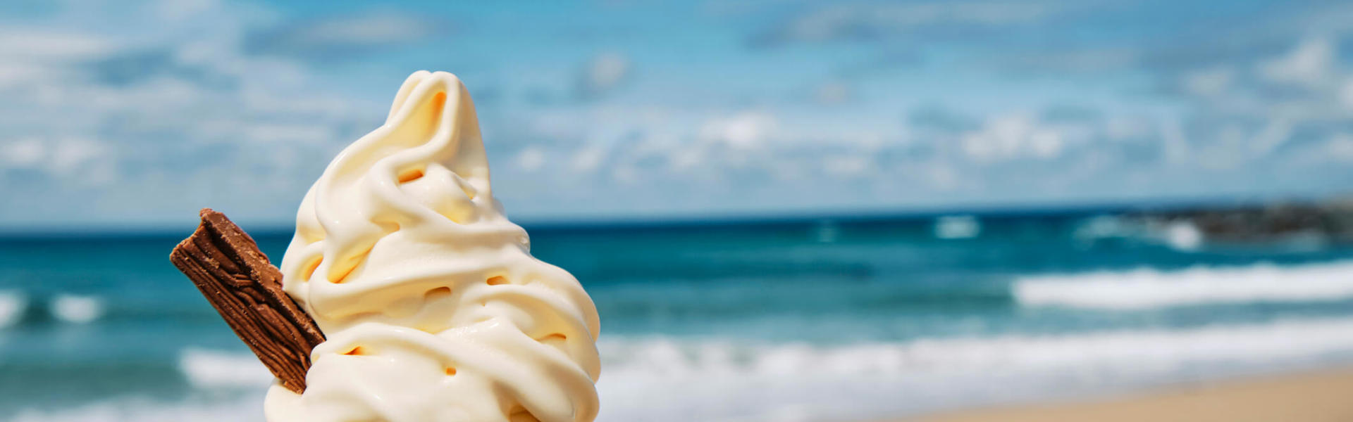a 99 cone ice cream with a flake against the backdrop of a seaside view