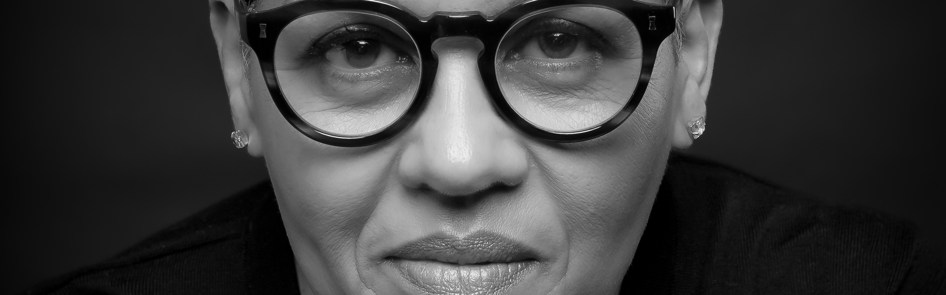 Main image: black and white headshot photo of novelist and author Kit de Waal, wearing glasses looking into the camera.