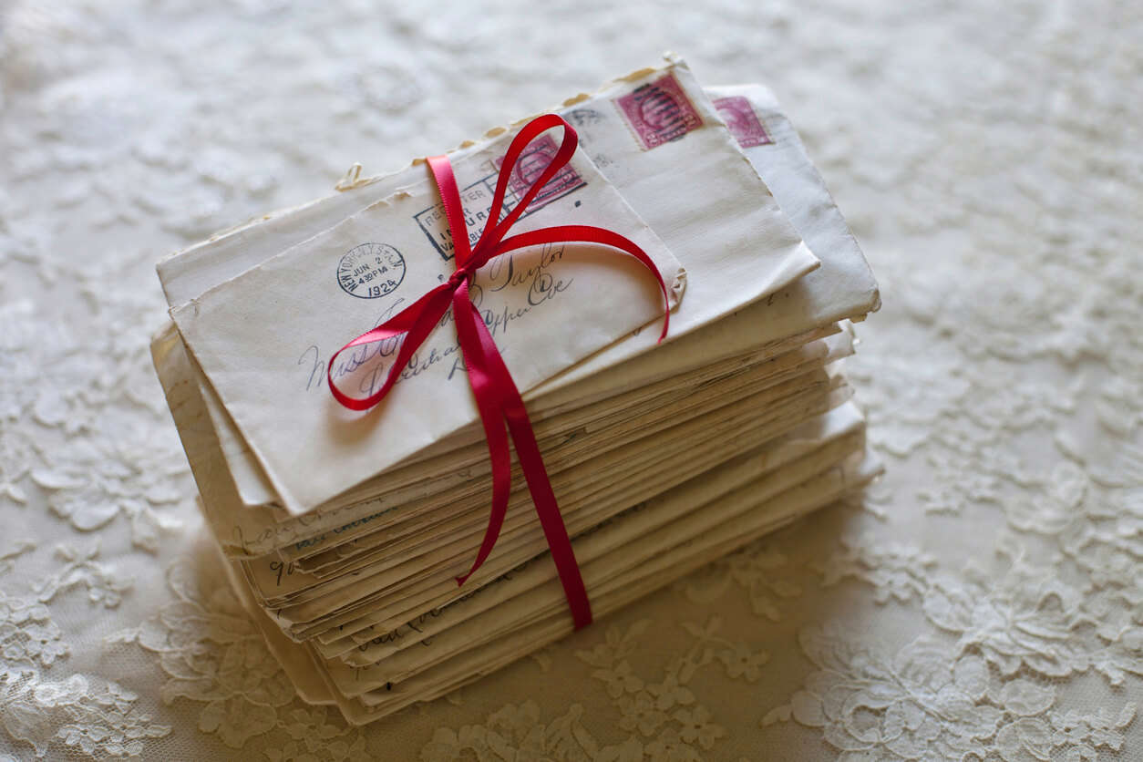 a stack of handwritten letters tied with a red bow
