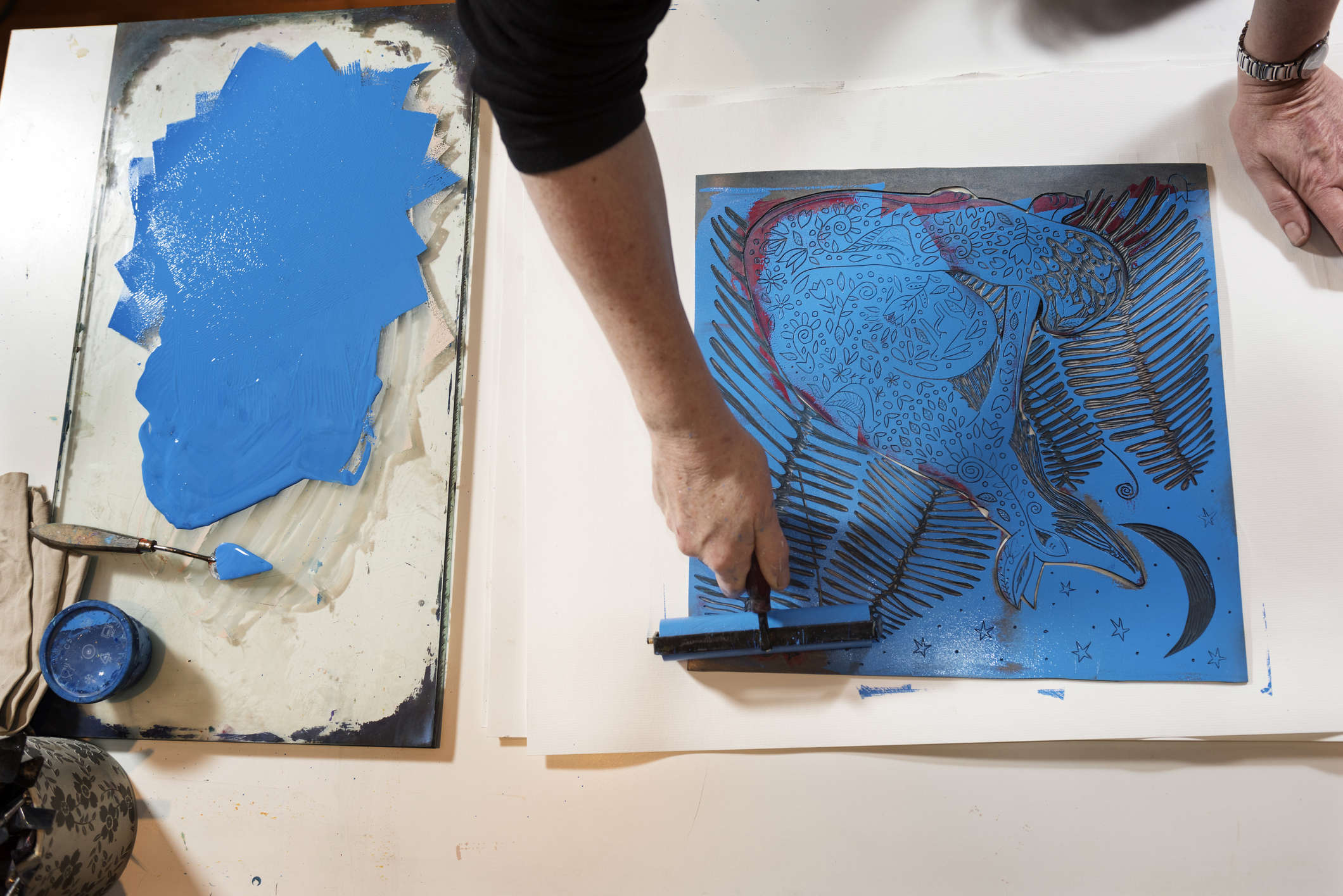 a person making a blue print work on a white surface