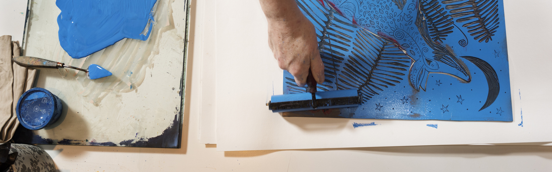 a person making a blue print work on a white surface