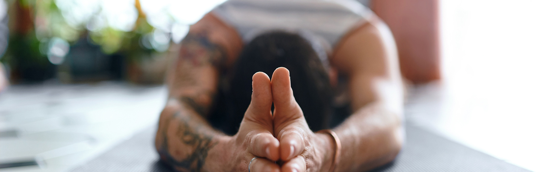 a picture of a man on a yoga mat with his hands above his head lying down in prayer position