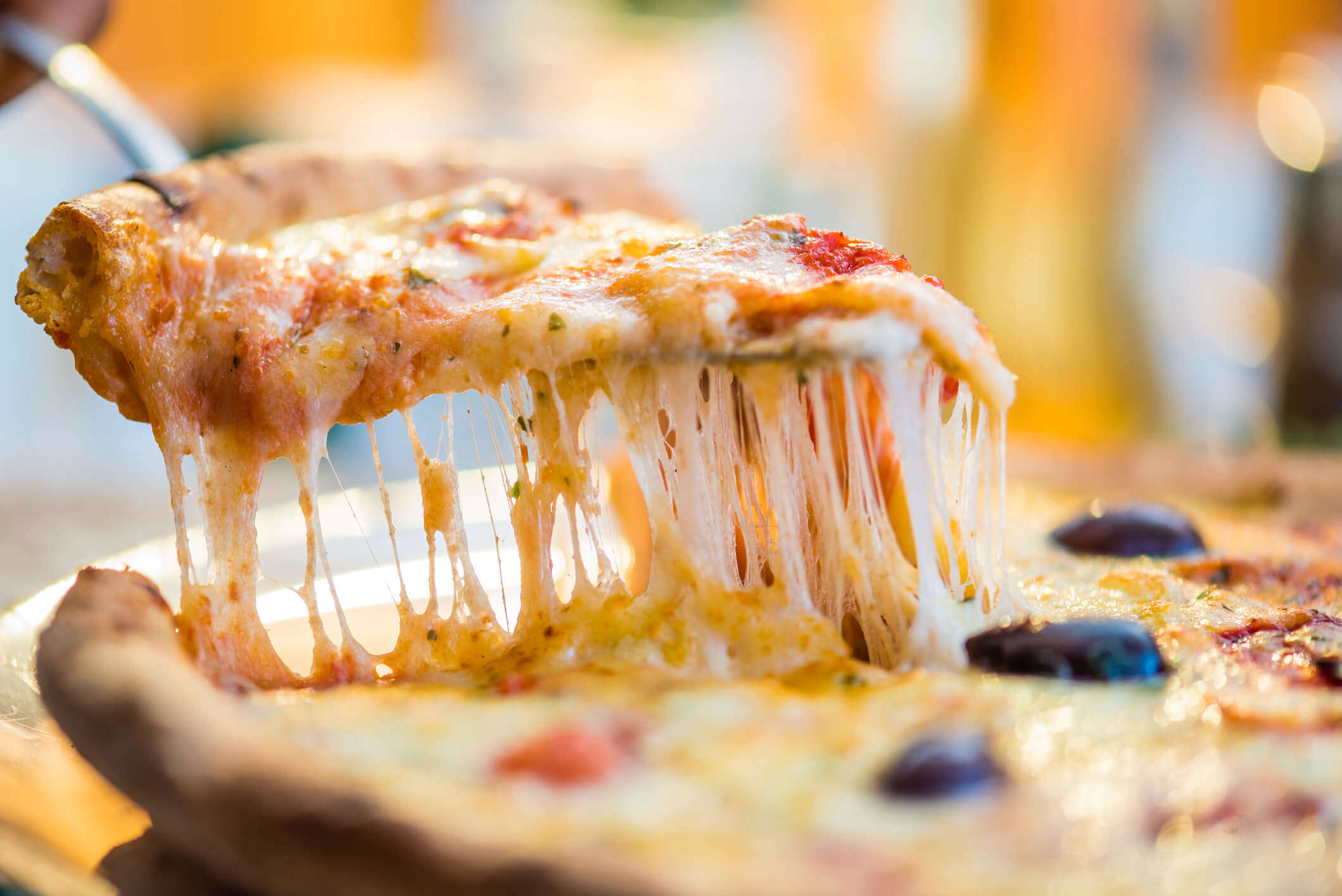 a close up of a slice of tomato and cheese pizza being served