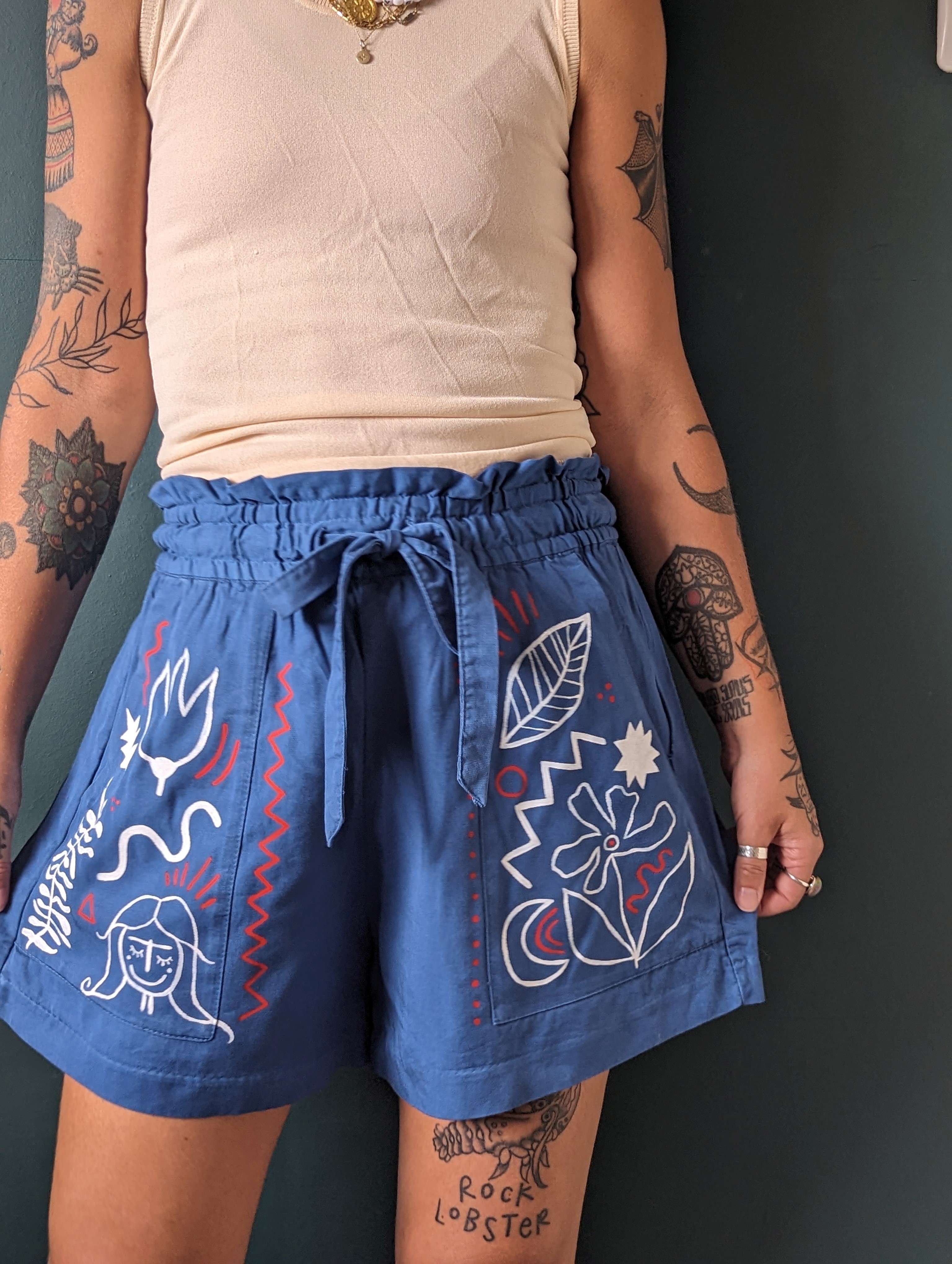 fabric painting on blue shorts by Rosie Johnson