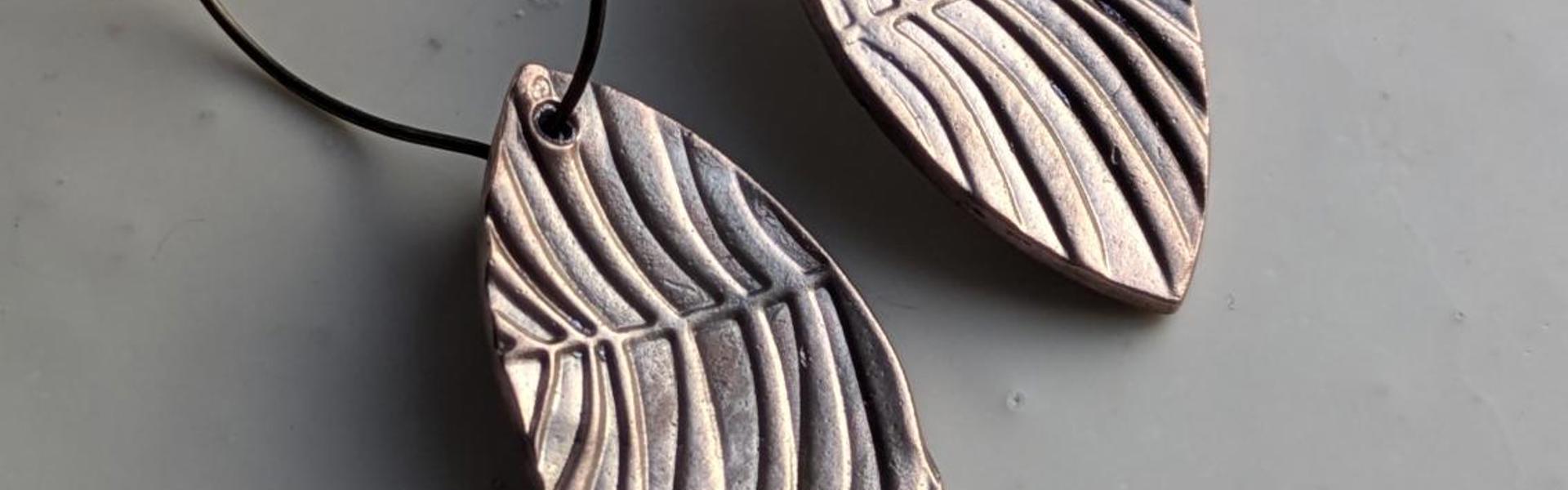 Main image: handmade copper clay earrings, with large hoops, and a leaf print design.