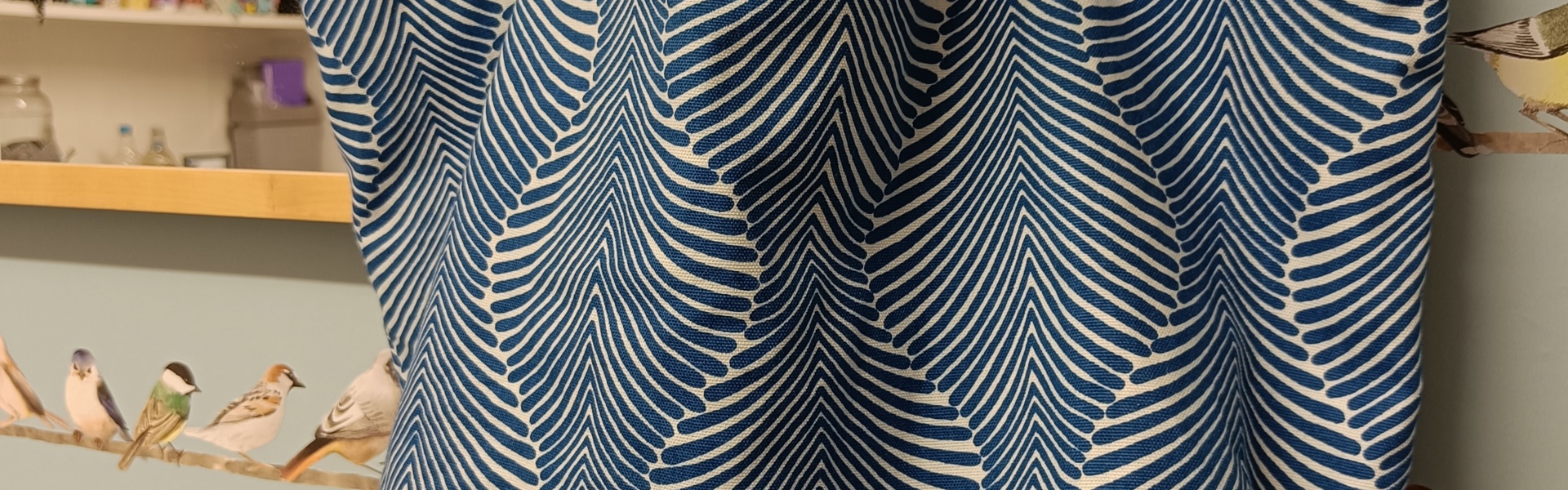 a handprinted summer canvas bag made by Gemma Forde hanging on the side of a wooden framed mirror