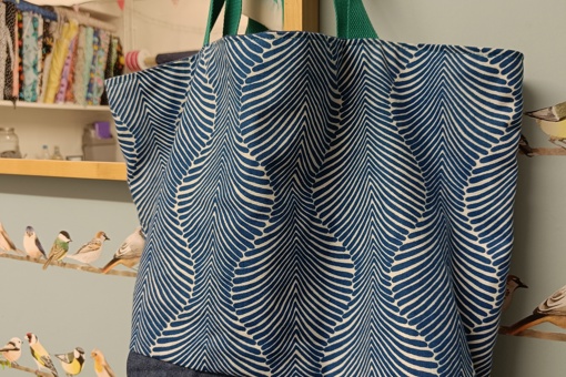a handprinted summer canvas bag made by Gemma Forde hanging on the side of a wooden framed mirror