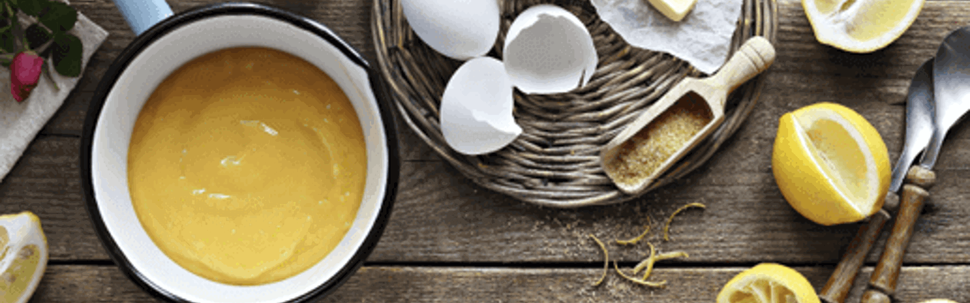 ingredients for lemon curd laid out on a wooden table