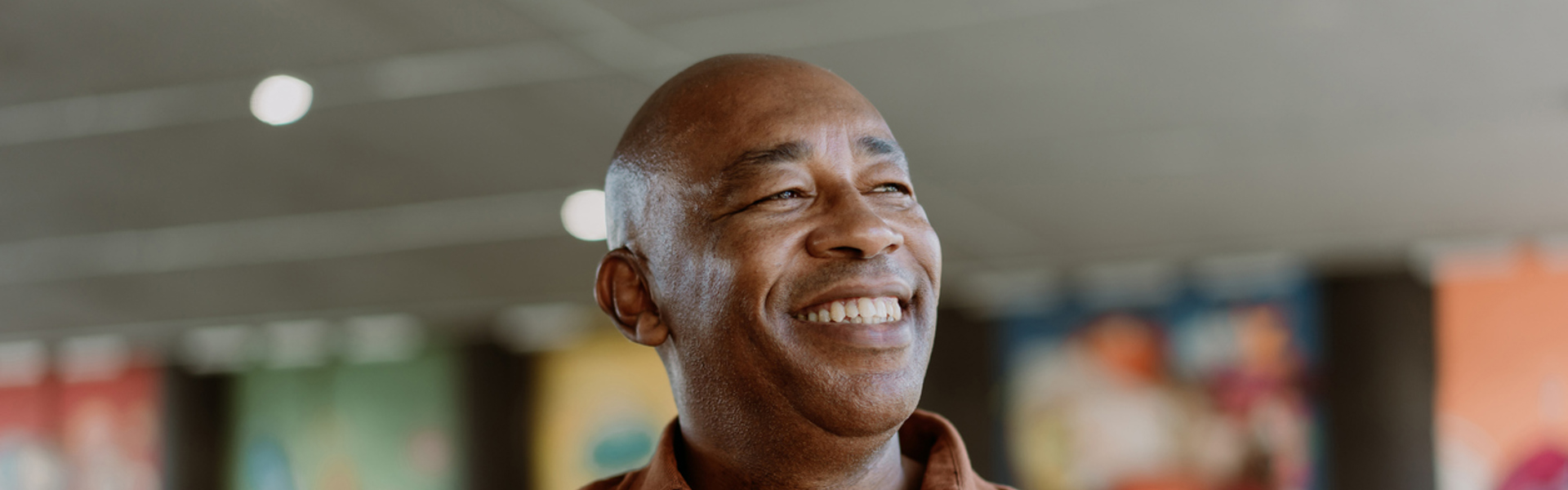 a man wearing a brown short sleeve shirt smiling
