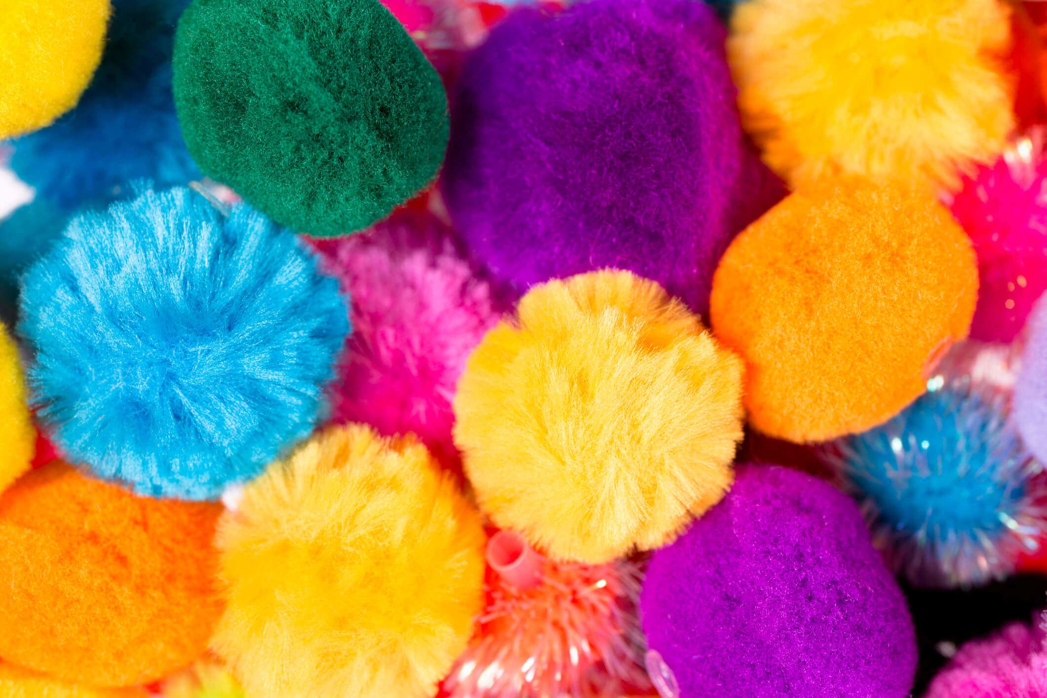 a close up of multicoloured pom poms