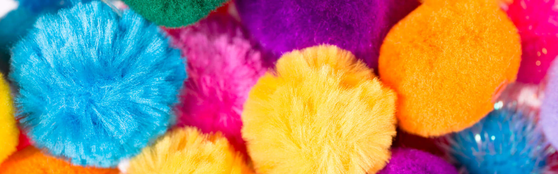 a close up of multicoloured pom poms