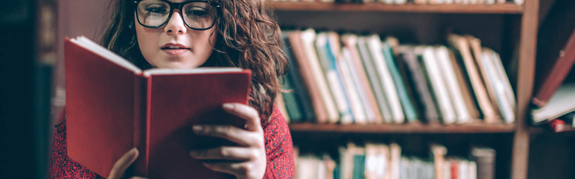 A woman reading a book in a library