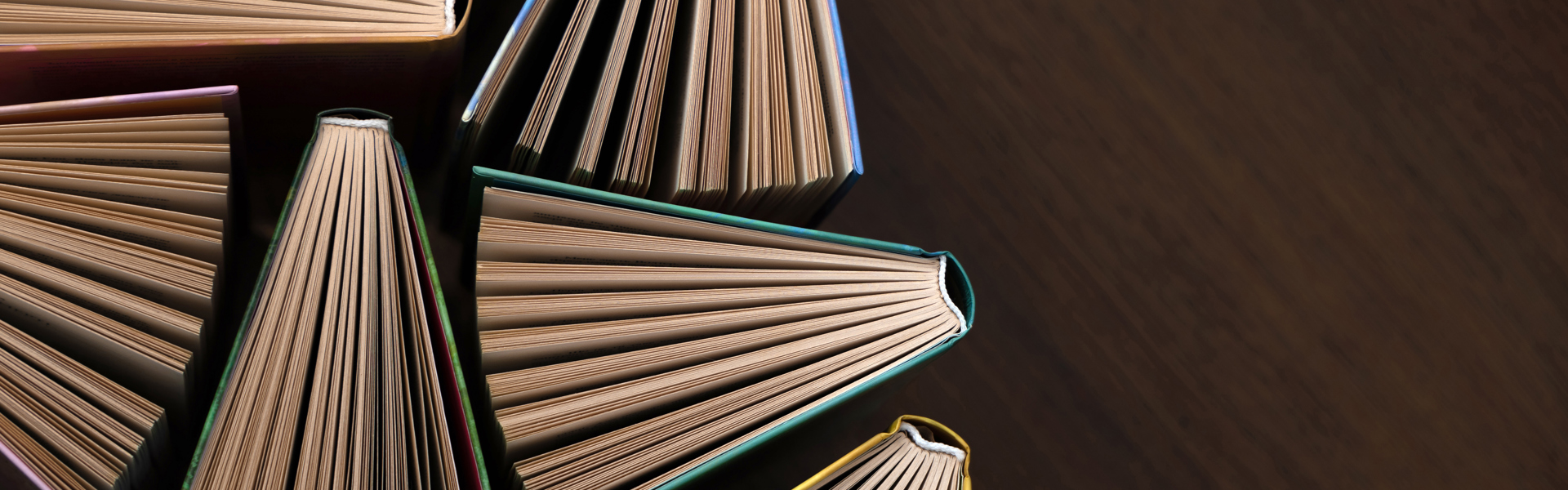 Main image: a view of open books and their pages from above.