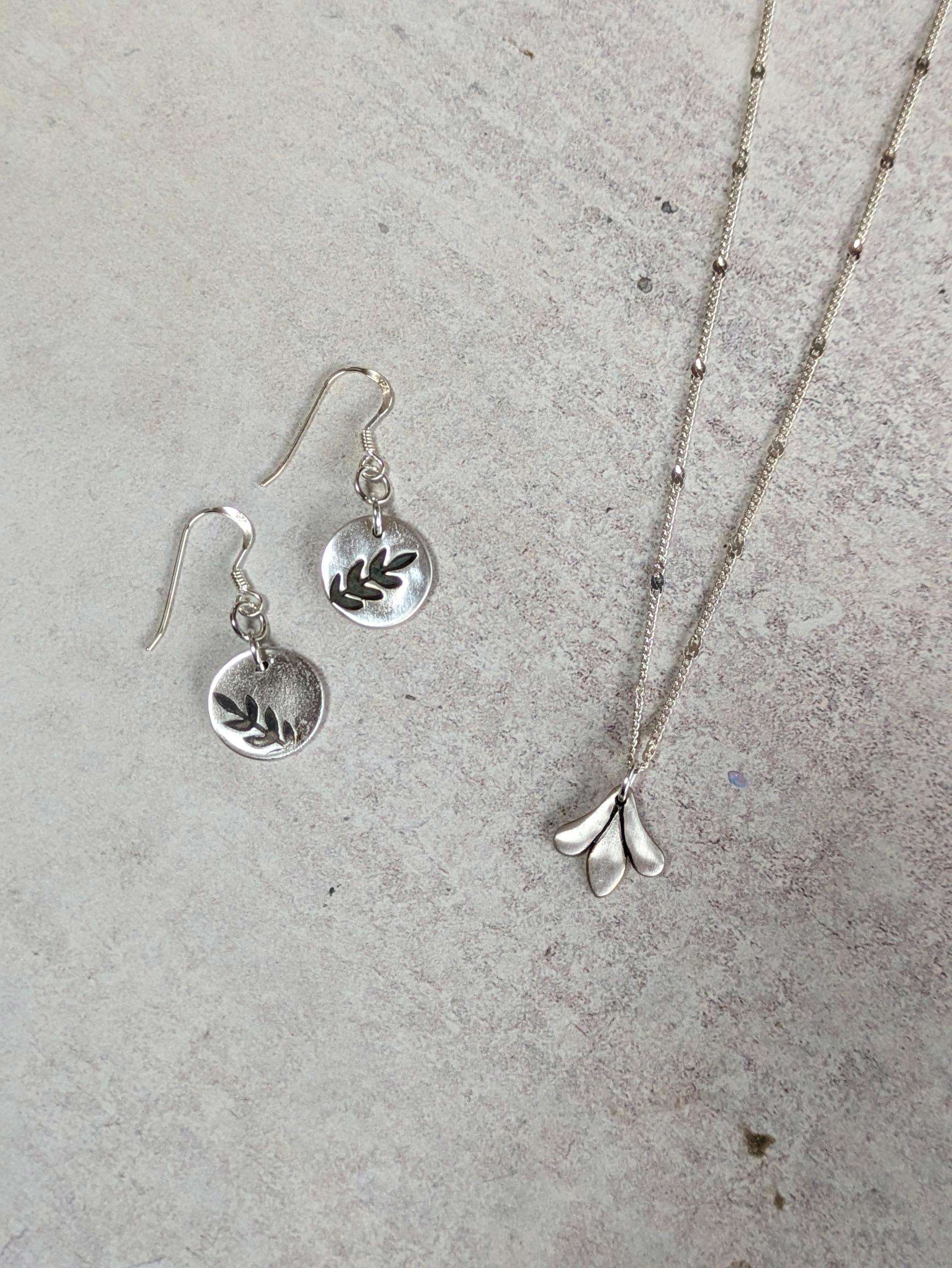 Silver clay jewellery, handmade pendants in earrings and a necklace with a leaf design imprinted.