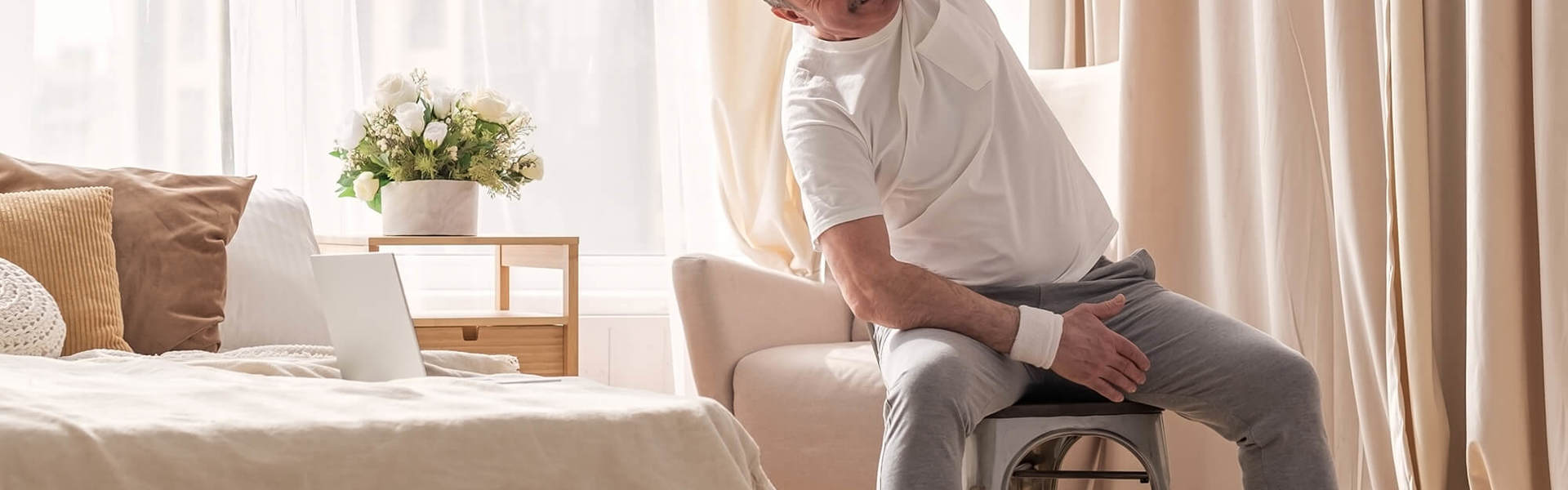 A man doing a seated exercise class at home