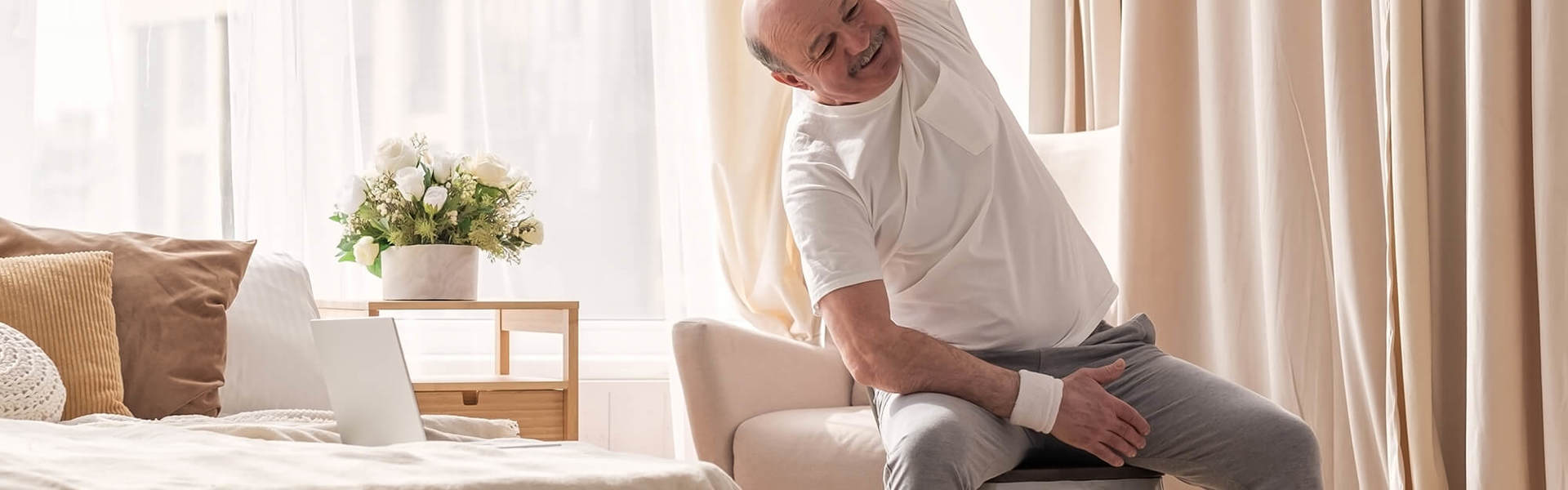 A man doing a seated exercise class at home