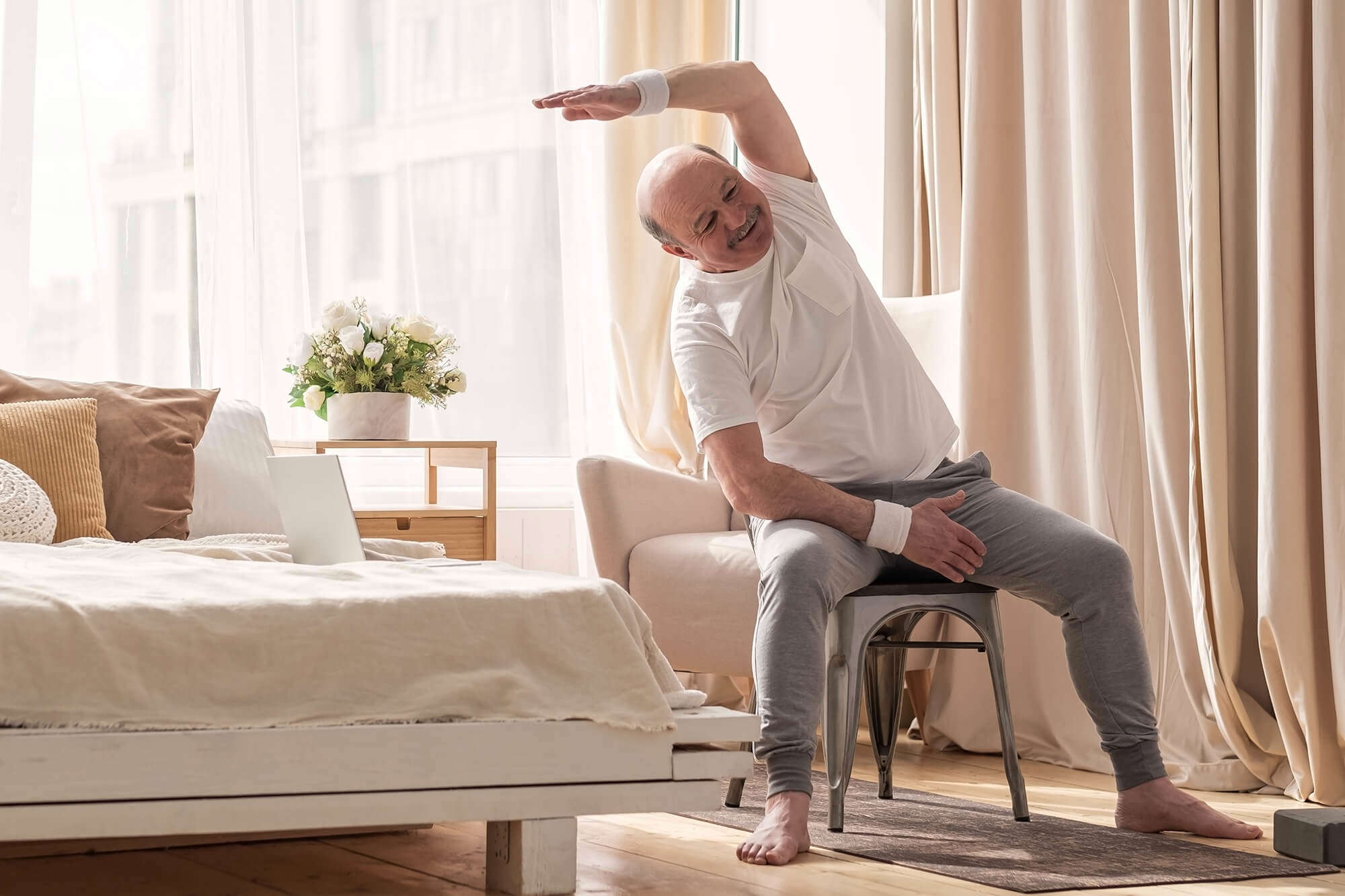 A man doing a seated exercise class at home