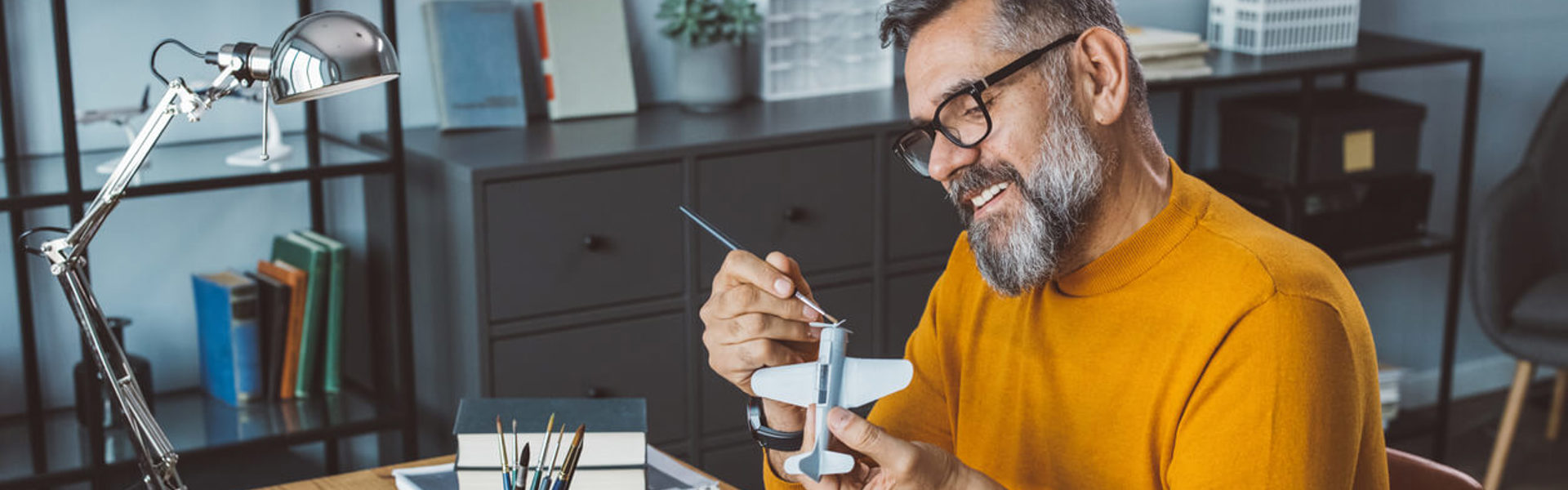 Mature man at office making plane model for next project.