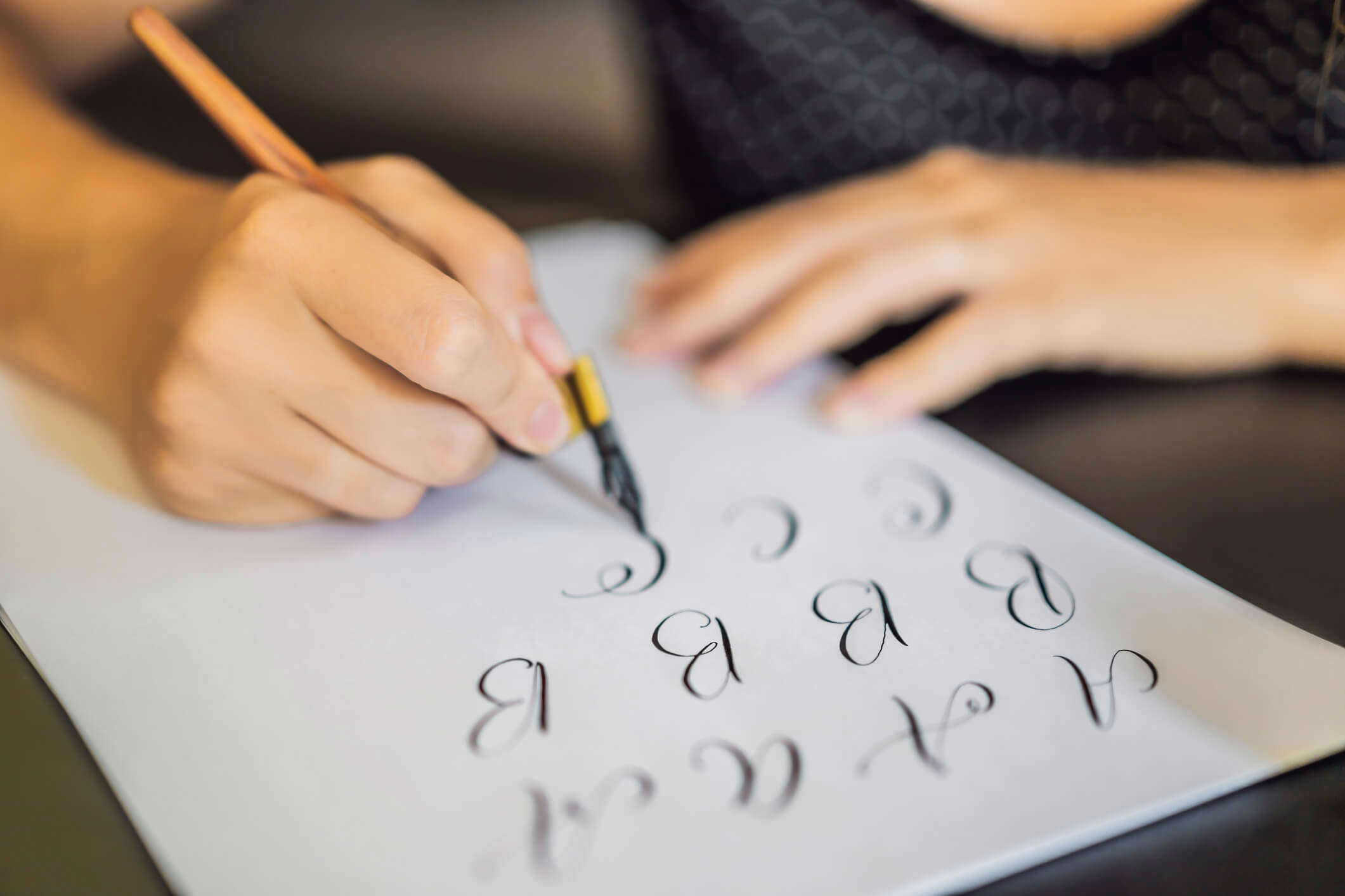 a close up of someone practicing calligraphy on a white piece of paper