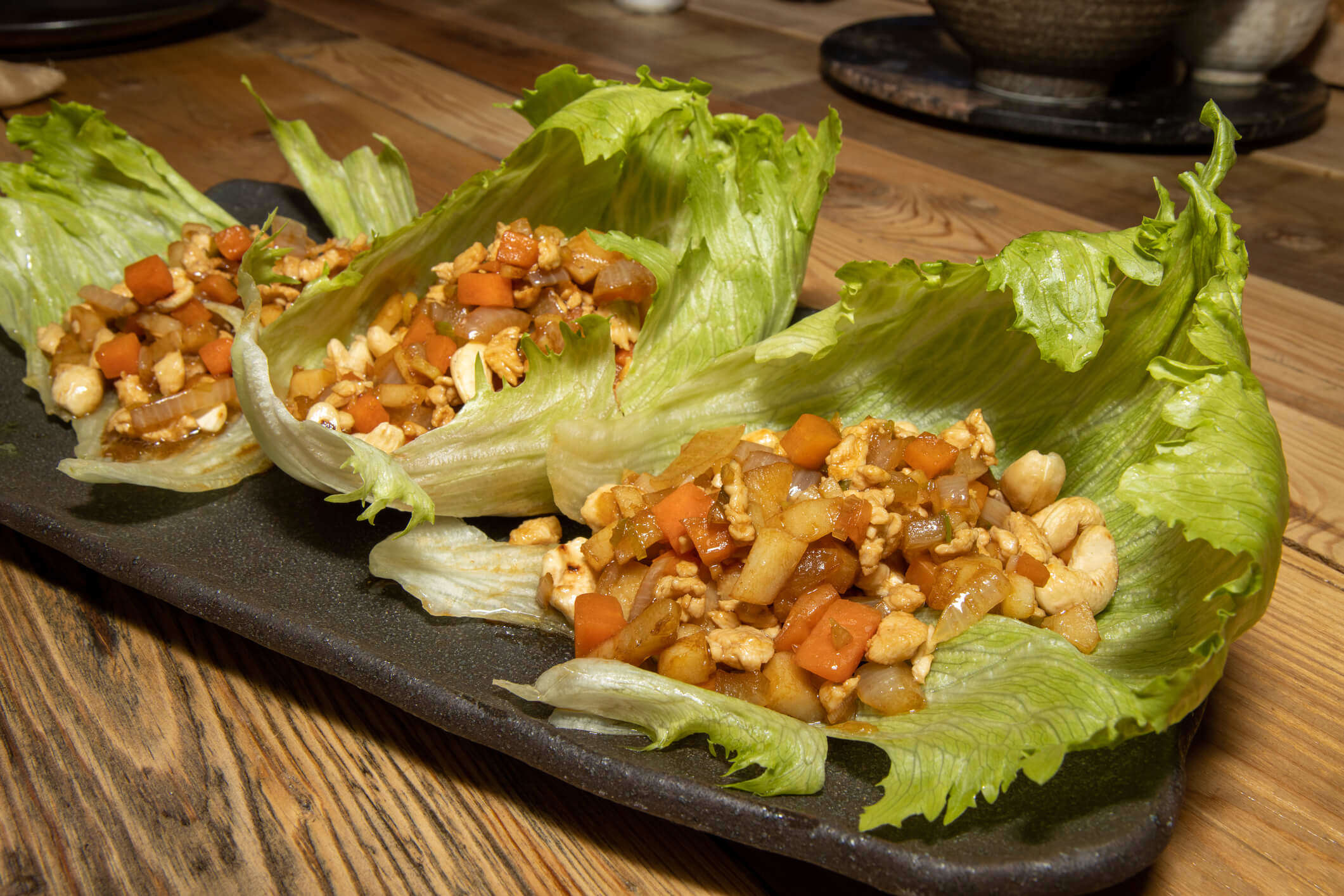 Main Image: Three lettuce leaves filled with Chicken Yuk Sung - AKA Chinese Lettuce Wraps.