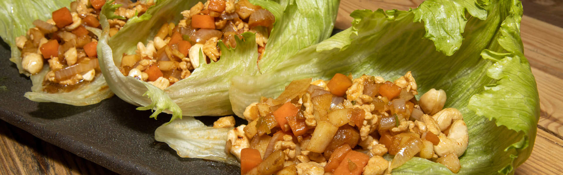 Main Image: Three lettuce leaves filled with Chicken Yuk Sung - AKA Chinese Lettuce Wraps.