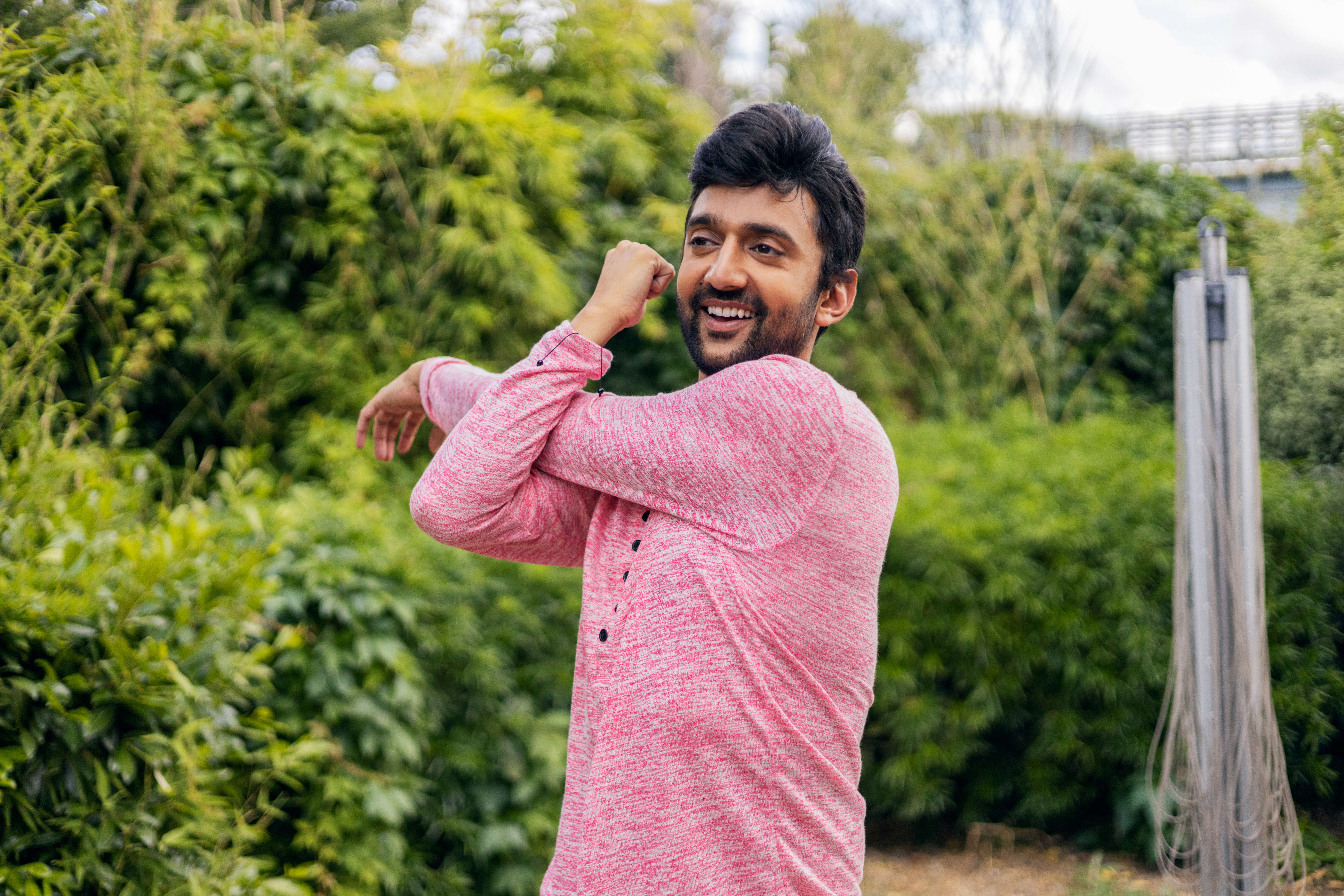Main image: a man in his garden stretching before a HIIT workout class.
