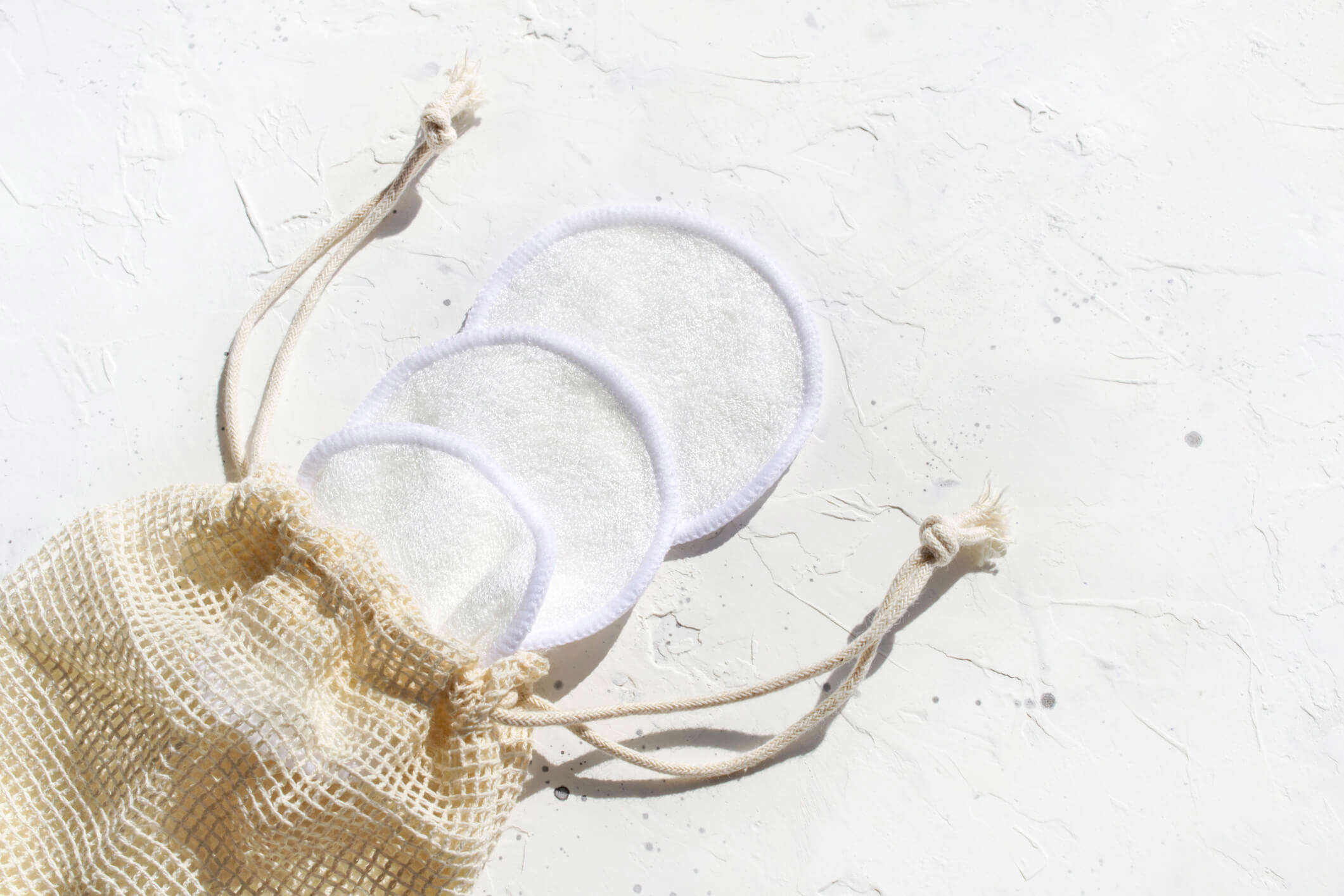 3 cotton reusable make up pads in a net bag