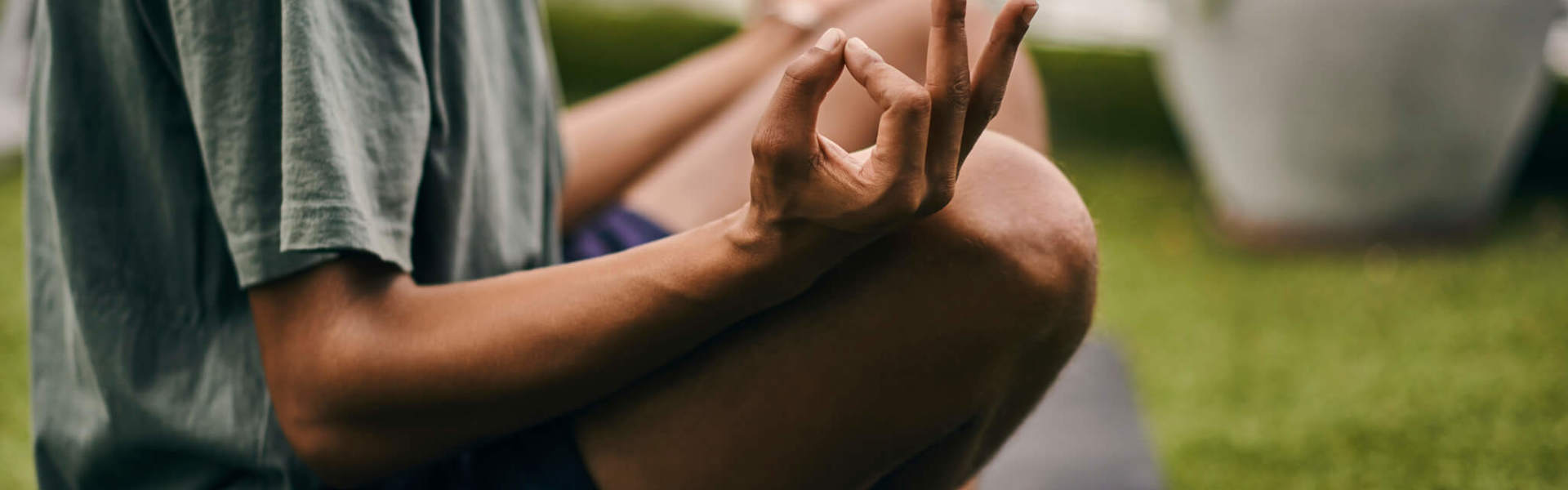 Man sitting in the lotus position, meditating in his garden.