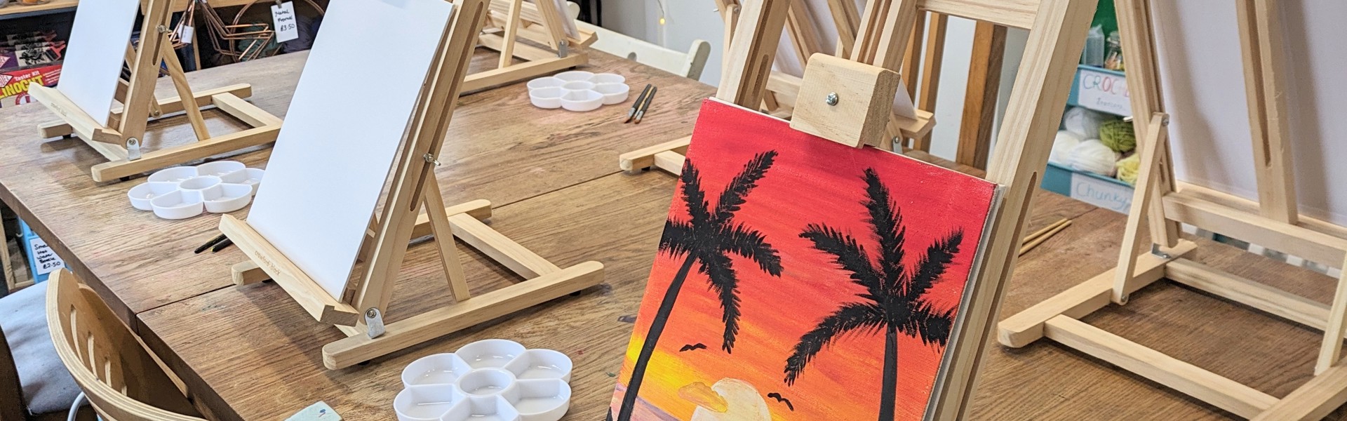 a hand painted tropical scene on a canvas resting on a easel