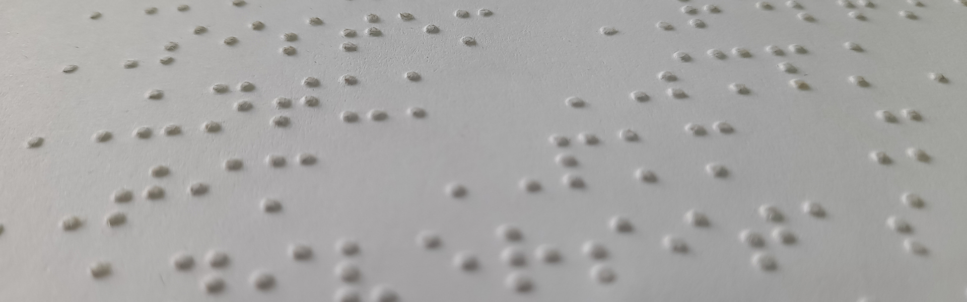 Main Image: A close up image of Unified English Braille (UEB) on white braille paper.