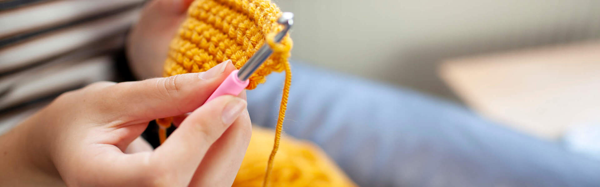 a close up of a crochet hook making a yellow garment