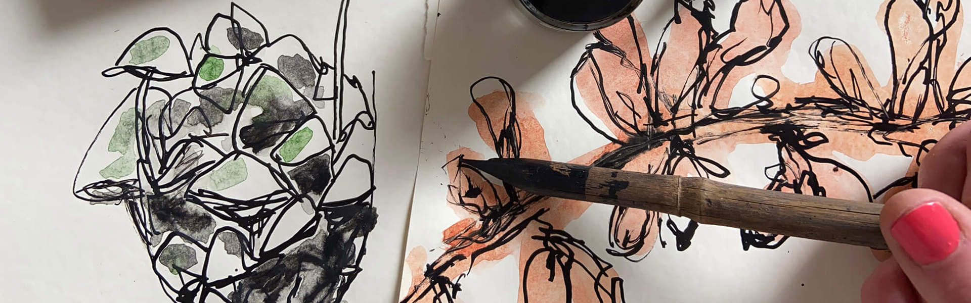 A close up of someone completing a bamboo dip pen and ink drawing