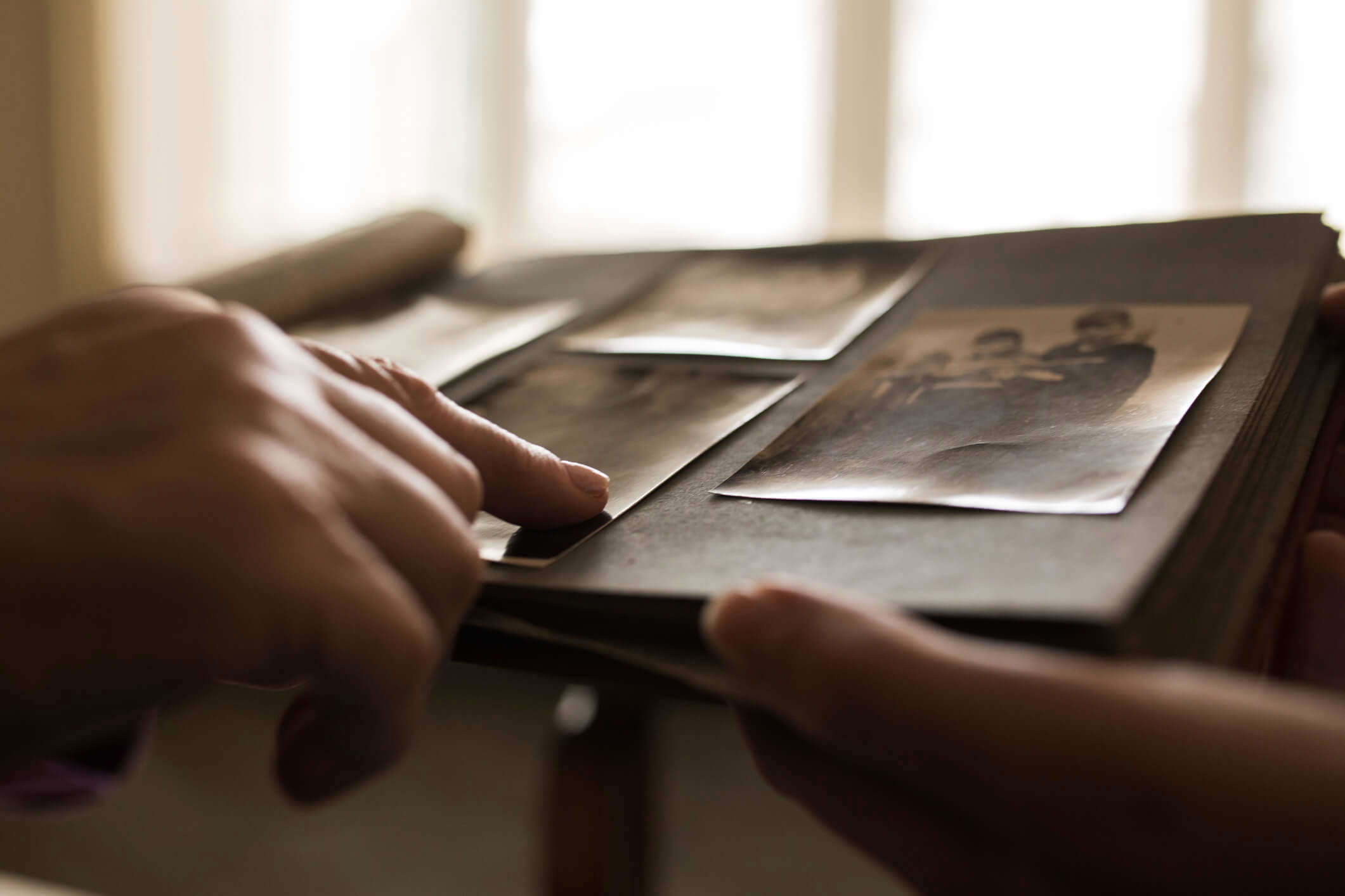 a close up of a person viewing old photographs in a album