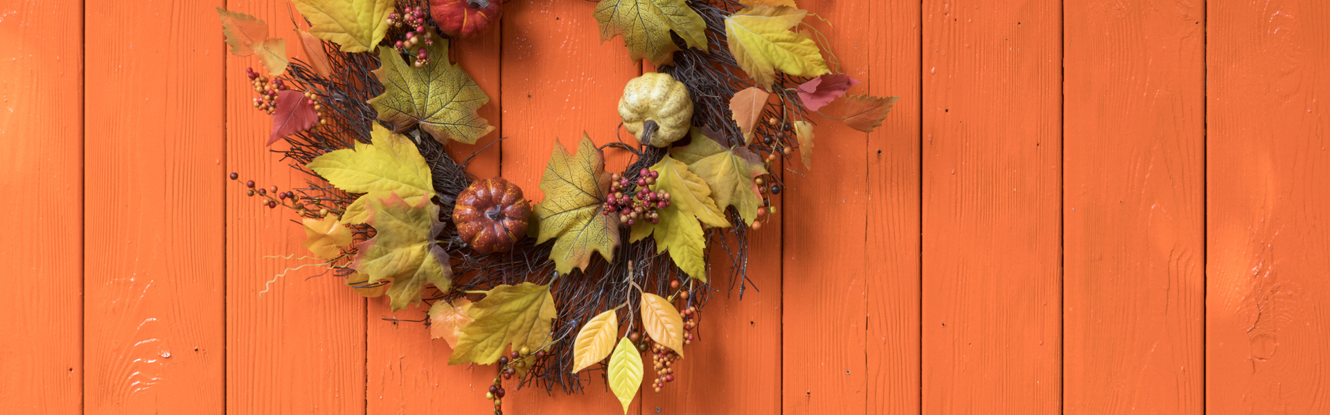An autumn leaf wreath on a wooden fence