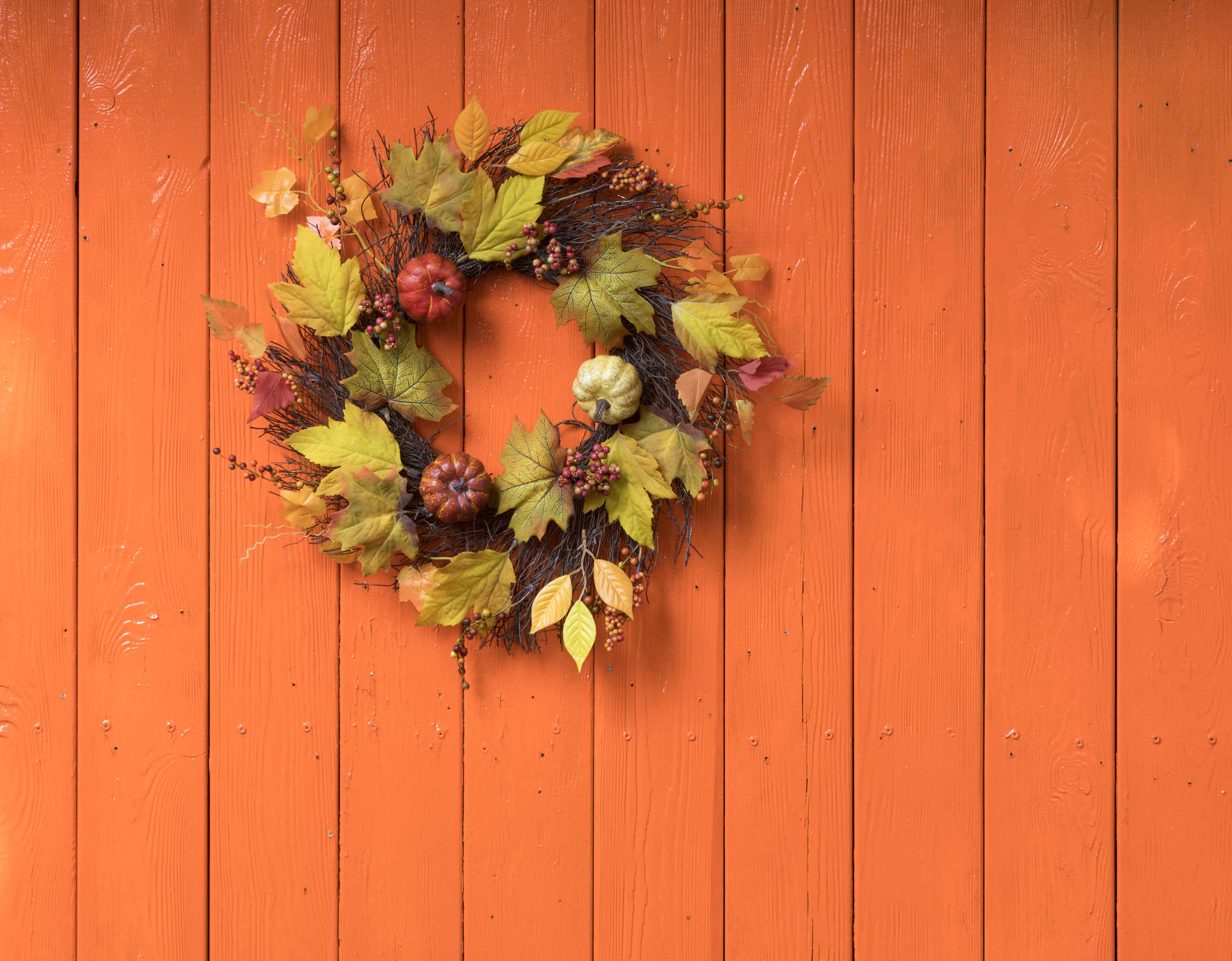 An autumn leaf wreath on a wooden fence