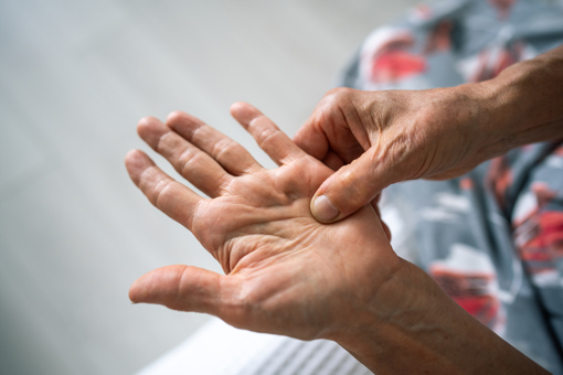 Person pinching an acupressure point in their hand, practising EFT Tapping for Feeling Overwhelmed. 
