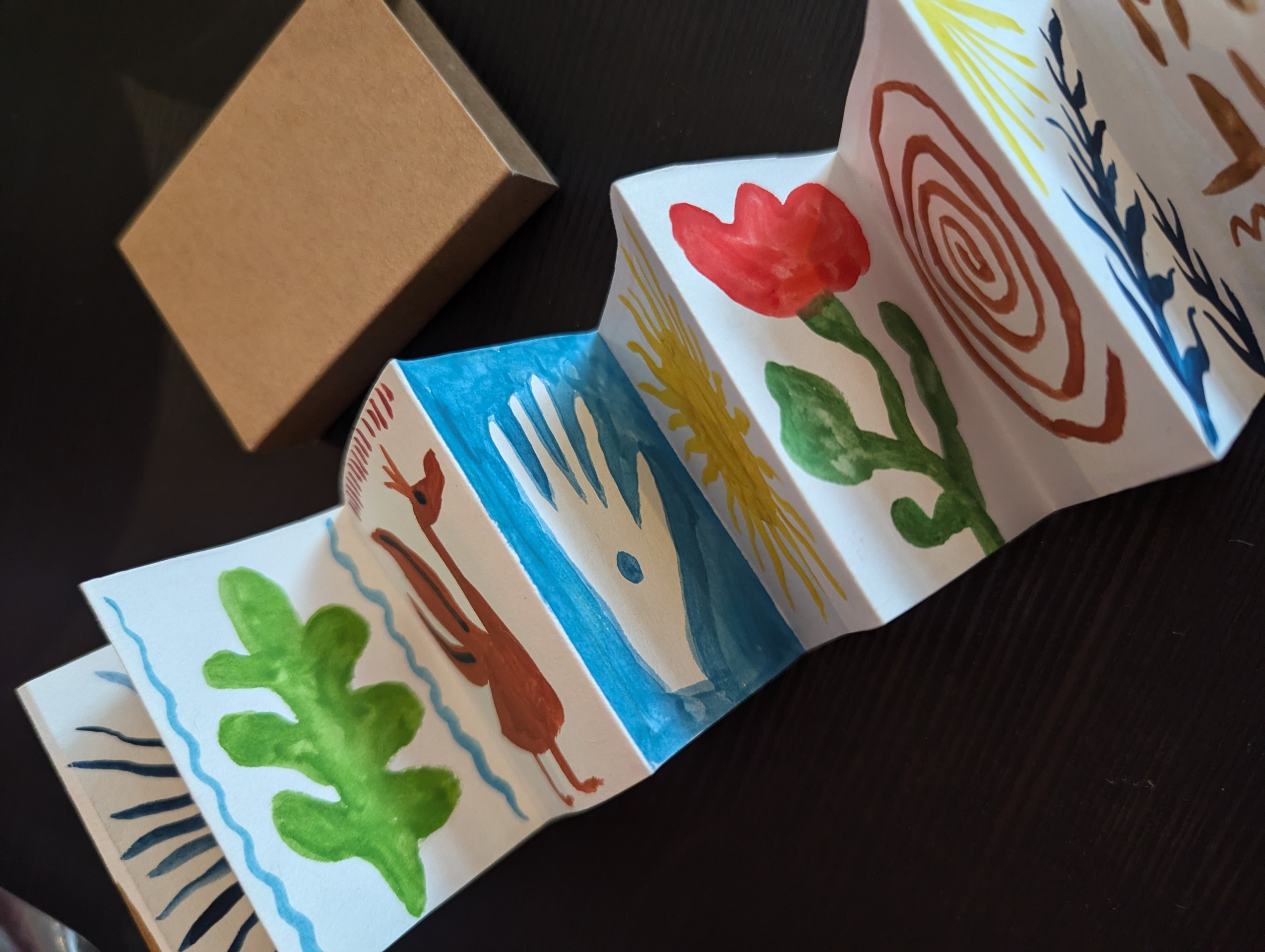Main image: Matchbox book craft idea - and a simple matchbox turned into a miniature concertina book – a unique handmade gift with little images painted on each page.